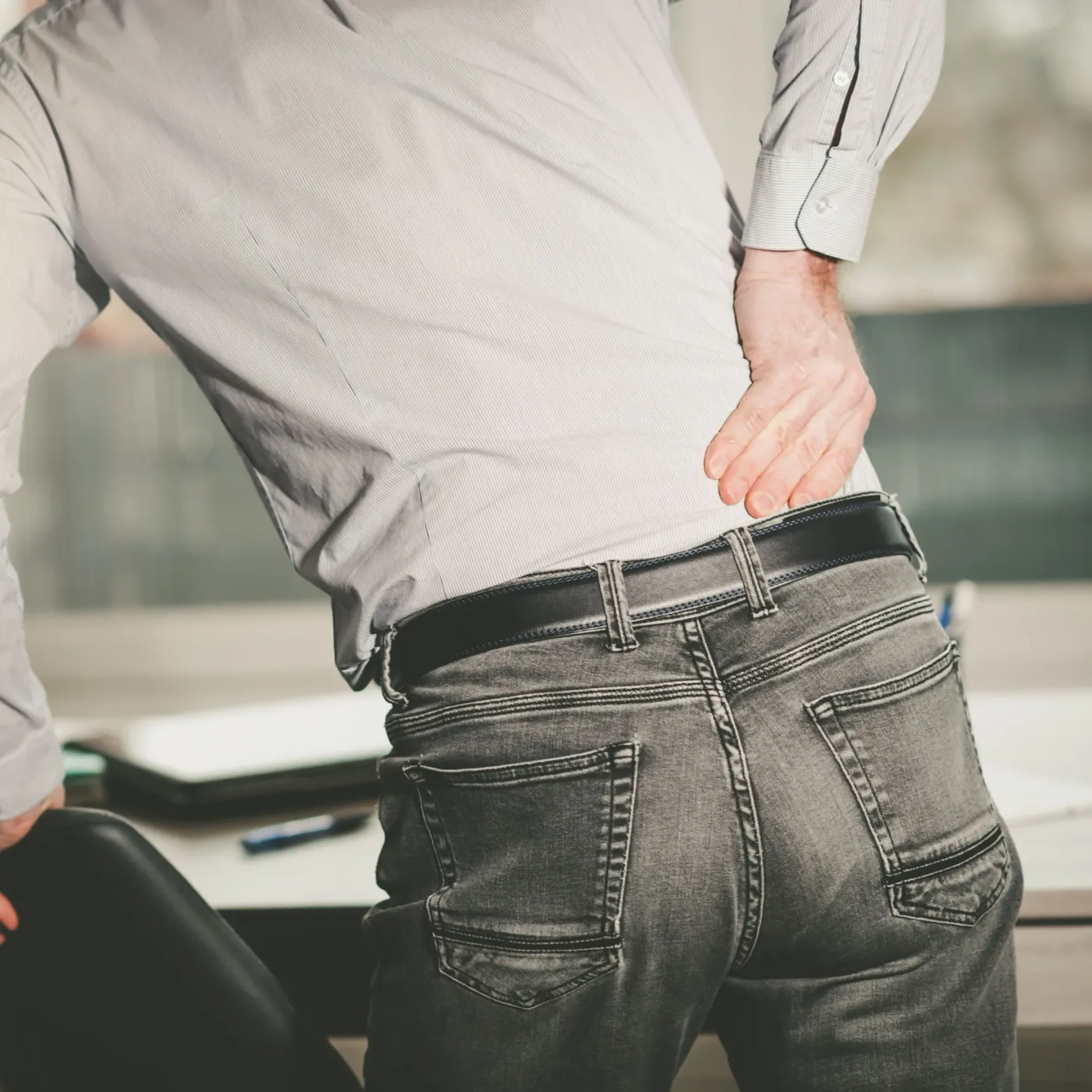 Person holding their lower back in discomfort
