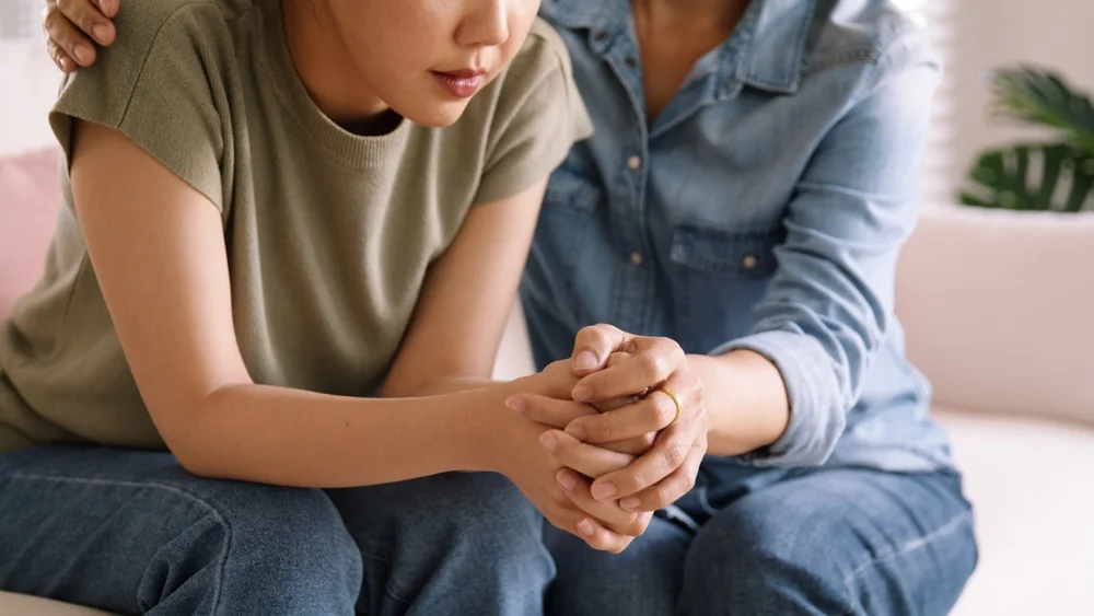 A supportive partner comforting someone dealing with chronic pain, showing the importance of understanding relationships.