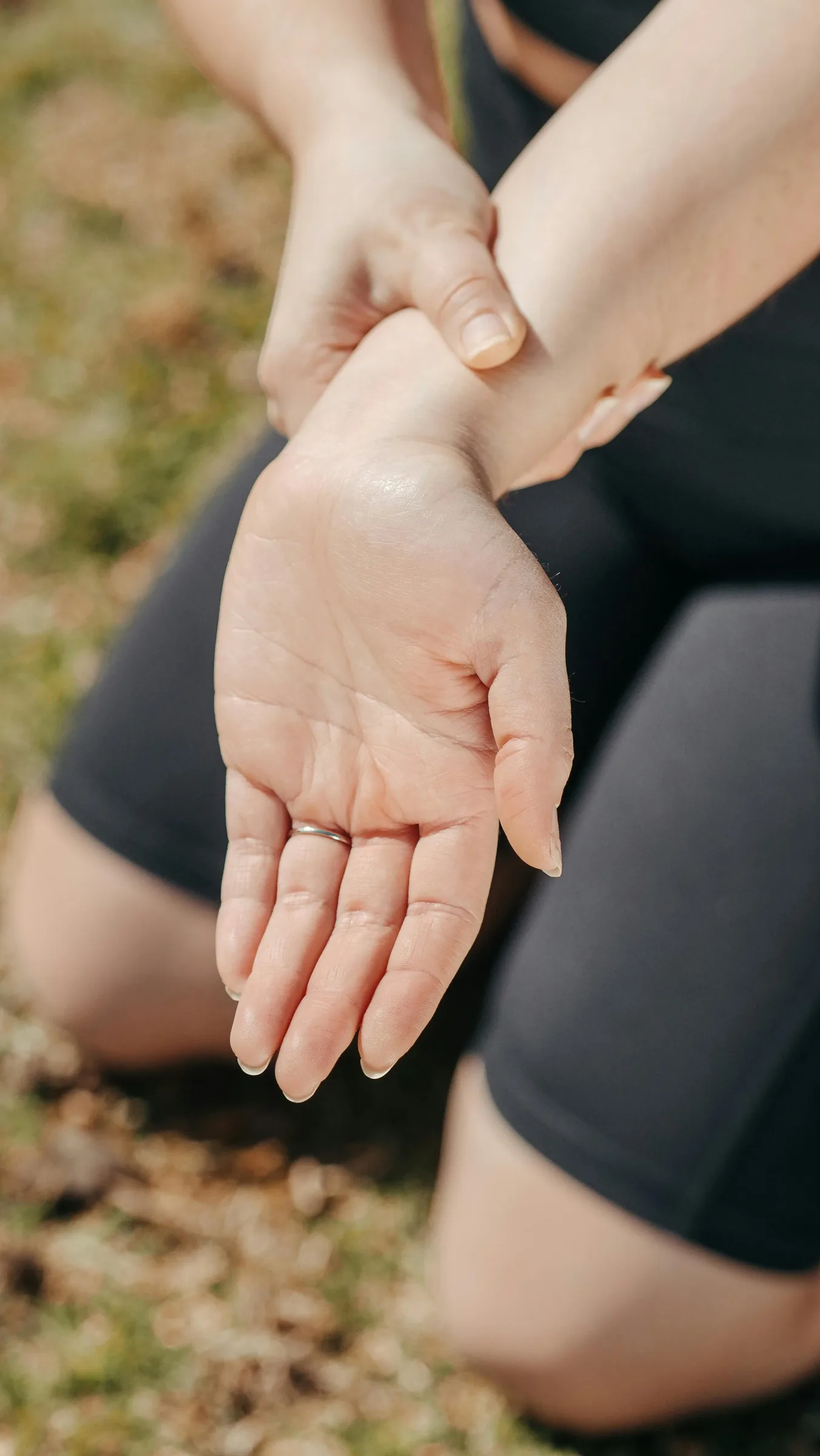 person holding their sore wrist outdoors